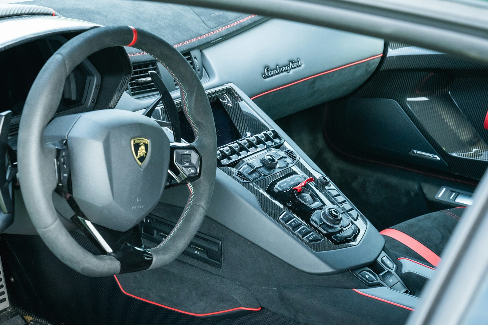 Lamborghini sports car interior with red accents and carbon fiber details