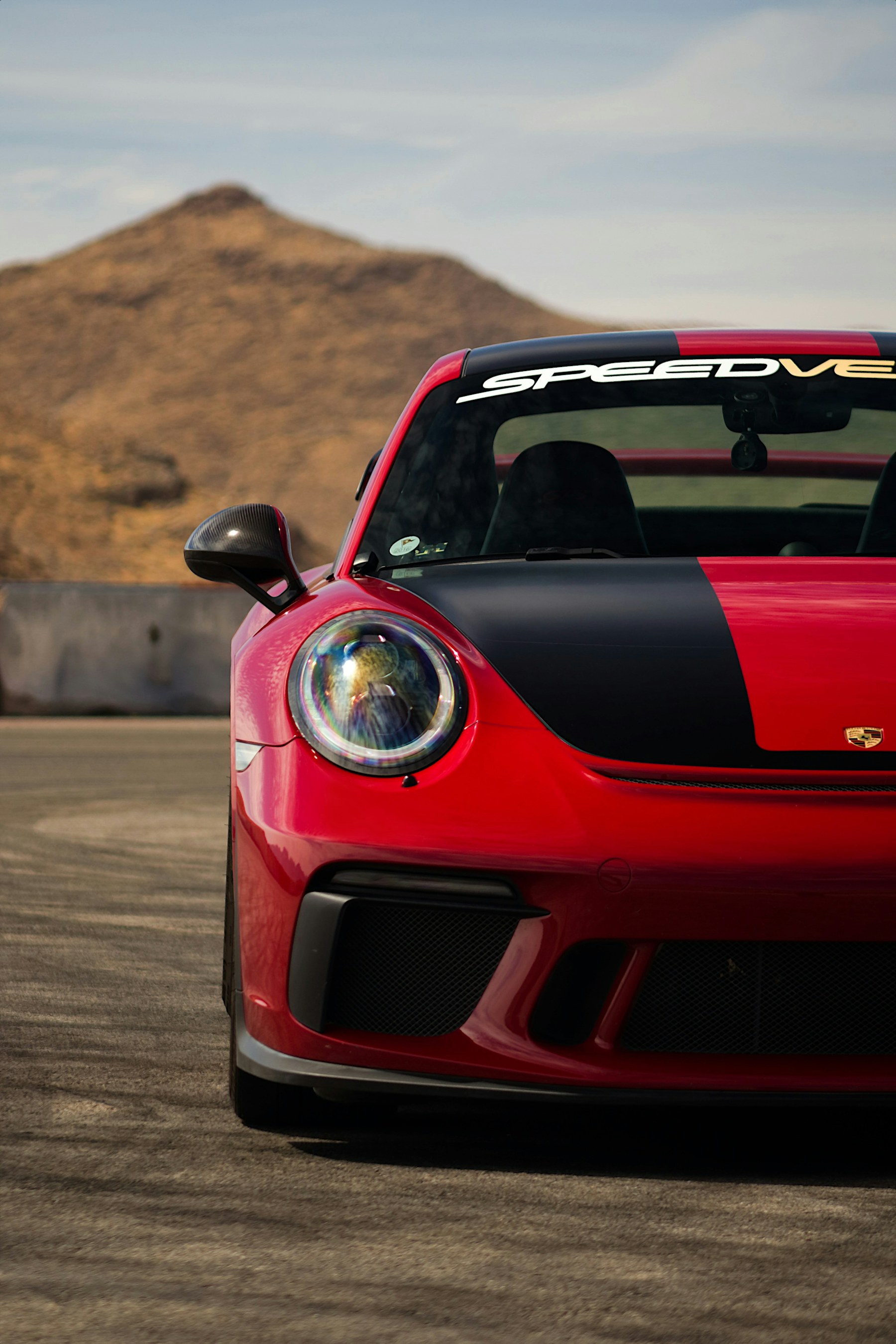 Red Porsche 911 GT3 front end photographed on a road